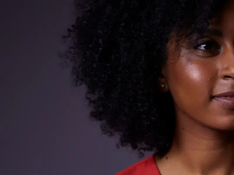 Photo of a black woman in a red dress smiling