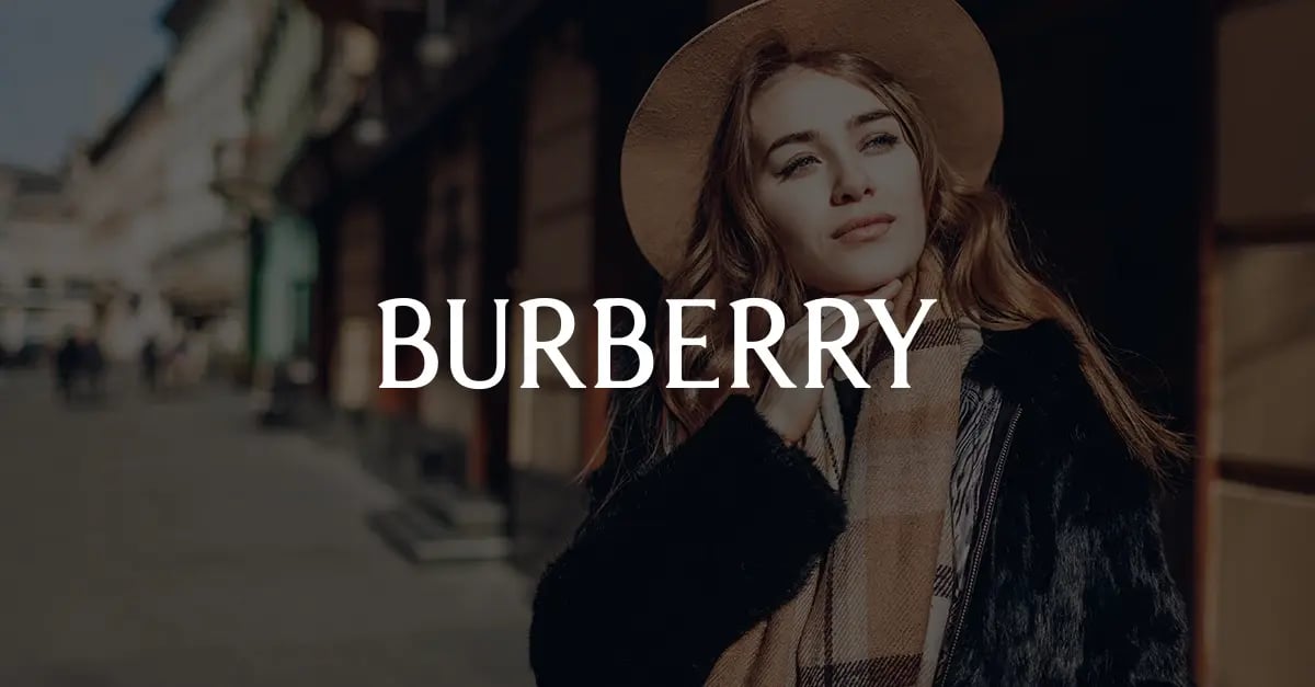 Photo of a woman stylishly dressed and standing on a city street with a white version of the Burberry logo superimposed in the middle foreground